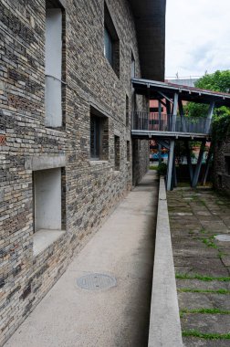 HANGZHOU, ÇİN - 08 Temmuz 2017: Çin Sanat Akademisi 'ndeki geri dönüşümlü taş ve tuğladan örülmüş duvarlar arasında dar bir ara sokak veya yol. Tahta bir köprü yukarıdaki binaları birbirine bağlıyor..