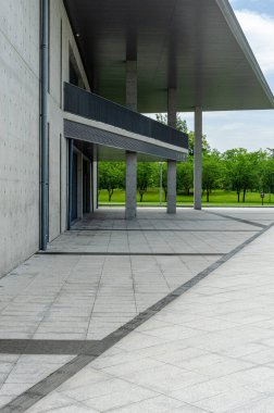 HANGZHOU, ÇİN - 06 Temmuz 2017: Hangzhou 'daki Liangzhu Sanat Merkezi' nin dış görünüşü. Fotoğraf, Tadao Ando 'nun tasarım tarzının tipik ham beton yapısı, geniş asma çatı ve asfalt kaldırımları vurgular..