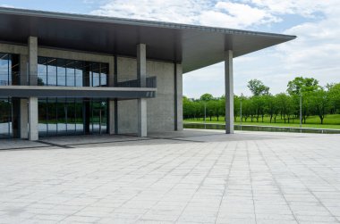 HANGZHOU, ÇİN - Temmuz 06, 2017: Liangzhu Sanat Merkezi 'nin dış görünüşü, imzanın büyük çatı yapısının altındaki beton duvarları ve cam perde duvarlarını gösteriyor, tipik Tadao Ando tasarım tarzında..