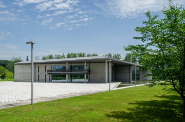 HANGZHOU, ÇİN - 06 Temmuz 2017 Çevredeki park çimlerinden Liangzhu Sanat Merkezi 'nin görüntüsü. Minimalist beton yapı, Liangzhu Kültür Köyü 'nün yeşil manzarasında huzur içinde duruyor..