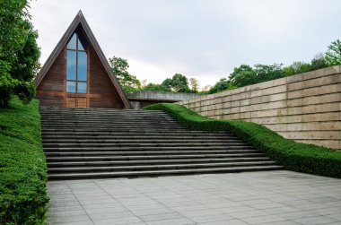 HANGZHOU, ÇİN - 06 Temmuz 2017: Liangzhu Kültür Köyü 'ndeki Meilizhou Kilisesi' nin (Meilizhou Tang) geniş görüşü. Ayırt edici ahşap üçgen kilise taş duvarlar ve yeşilliklerle çevrili geniş taş merdivenlerin üzerinde duruyor..