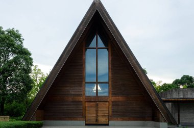 HANGZHOU, ÇİN - 06 Temmuz 2017: Meilizhou Kilisesi 'nin ayırt edici üçgen ahşap mimarisinin tam öngörüsü. Geometrik tasarım, barışçıl Liangzhu Kültür Köyü 'ndeki yeşil ağaçların arasında duruyor..