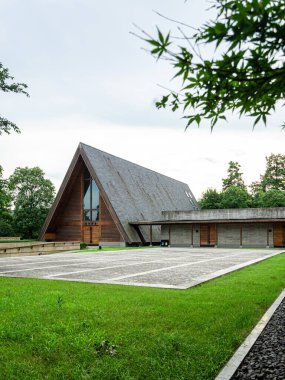 HANGZHOU, ÇİN - 06 Temmuz 2017: Meilizhou Kilisesi 'nin yan profiline dik bakış, uzun eğimli çatı, taş kaldırım ve yeşil çimenleri gösteriyor. Bina manzarada uyum içinde duruyor..