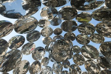 Geniş açı görüşü, halka açık bir sanat tesisinde asılı duran aynalı çelik küre kümesine bakarak karmaşık bir geometrik görsel yaratıyor..