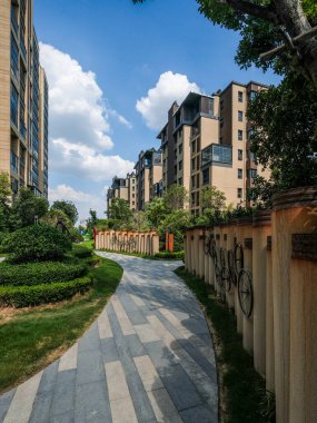 Yaya geçidinin dikey bir manzarası var. Çağdaş bir yerleşim alanının duvarları yemyeşil ağaçlarla çevrili..