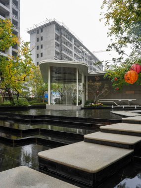 Geleneksel dekoratif fenerlerle vurgulanan bir su havzasının içinden geçen geometrik taş basamakların yer aldığı manzaralı bir alan. Görüntü zarafeti, kültürel birleşmeyi, mimari yapıyı ve huzurlu yaşamı aktarıyor. Yüksek kalite gerçek fotoğraf.