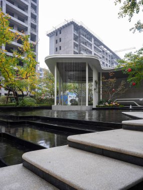 Modern bir bahçe bahçesindeki yansıtıcı havuzun üzerinden temiz kesilmiş taş adımların perspektif görüntüsü. Görüntü hassasiyeti, mimari güzelliği, minimalizmi ve meditasyon ortamını yansıtıyor. Sığ alan derinliğine sahip yüksek kaliteli gerçek fotoğrafçılık