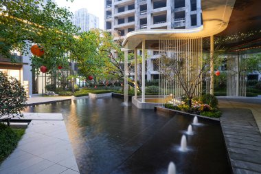 Günbatımında modern bir avluda, çaktırmadan aydınlatılan çağlayan bir su özelliği. Görüntü, akşam barışı, mimari zarafet, rahatlama ve sükunet getiriyor. Sığ alan derinliğine sahip yüksek kaliteli gerçek fotoğrafçılık.