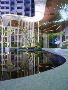 Pürüzsüz, modern bir pavyonun gece manzarası mükemmel bir şekilde karanlık ve durgun bir bahçe havuzuna yansıyor. Görüntü derin dinginliği, mimari güzelliği, meditasyonu ve üst düzey sükuneti aktarıyor. Sığ alan derinliğine sahip yüksek kaliteli gerçek fotoğrafçılık.