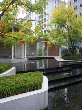 Ağaçların, çağlayan suyun ve akşamın erken saatlerinde modern bir pavyonun yer aldığı sakin bir bahçe. Görüntü, doğa entegre tasarım, sükunet, tazelik ve sofistike bir açık hava yaşam tarzı sunuyor. Şallo ile yüksek kaliteli gerçek fotoğrafçılık