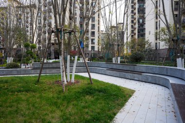 Kıvrımlı taş kaldırım yolu alçak istinat duvarı ve sakin bir yerleşim bölgesinde manikürlü yeşil çimlerin yanında. Görüntü, uyumlu bir ortam ve huzurlu bir yaşam sunuyor. Doğal ışıklandırmalı yüksek kaliteli gerçek fotoğrafçılık