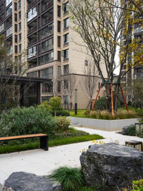 Süslü bahçe düzenleme kayaları, ahşap bir bank ve sakin bir bahçe bahçesinde yeşil çalılar yanından geçen Paved geçidi. Görüntü sakin bir vaha ve iyi korunan bir açık hava ortamı sunuyor. Yüksek kaliteli gerçek fotoğrafçılık.