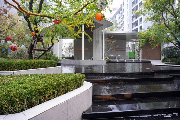 Manikürlü çitlerin, su kanallarının ve ağaçların yer aldığı canlı yeşil bir açık alan doğanın ve modern tasarımın uyumlu bir karışımını oluşturuyor. Görüntü canlılığı, büyümeyi, barışı ve lüks yaşamı aktarıyor. Sığ d ile yüksek kaliteli gerçek fotoğrafçılık