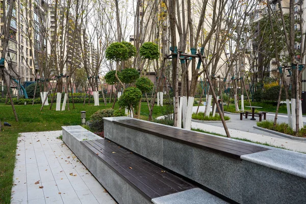 Uzun ve modern bank, asfalt bir yol ve sakin bir avluda manikürlü küresel çalıları birleştiren bir ahşap ve taşı birleştiriyor. Resim, topluluğun boş zamanlarını ve zarif manzara tasarımlarını aktarıyor. Doğal ışıklandırmalı yüksek kaliteli gerçek fotoğrafçılık