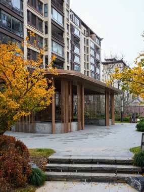 Taştan merdivenlerin ve yerleşim yerlerindeki parlak sarı sonbahar ağaçlarının arkasındaki çağdaş ahşap pavyon. Görüntü huzur vahası ve ahenkli mimari tasarım taşır. Doğal ışıklandırmalı yüksek kaliteli gerçek fotoğrafçılık.