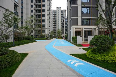 Bereketli bir mesken bahçesinde uzanan parlak mavi bir yolu olan modern bir taş yürüyüş yolu. Görüntü şehir aktivitelerini, tasarım yeniliklerini renkli ayrıntıları ve huzurlu bir mahallede yaşamayı aktarıyor. Sığ ve yüksek kaliteli gerçek fotoğrafçılık