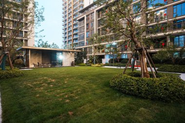 Huzurlu, güzel aydınlatılmış bahçe alanı. Temiz bir çimenlik ve konut ortamında mimari bir pavyon. Görüntü dengeyi, durgunluğu, akşam sükunetini ve son model dış tasarımı sağlar. Sığ derinliğe sahip yüksek kaliteli gerçek fotoğrafçılık