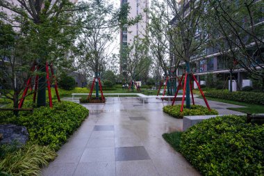 Alacakaranlıkta yemyeşil bir konut bahçesinde, yumuşak zemin ışıklarıyla parıldayan güzel, bakımlı bir taş patika. Resim huzurlu bir akşam yürüyüşü, doğa bağlantısı ve kentsel tasarım içeriyor. Sığ ve yüksek kaliteli gerçek fotoğrafçılık