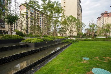 Huzurlu, çağdaş çağdaş çağlayan su havzası ve bakımlı bir bahçe parkındaki yeşil çimlere geniş bir bakış açısı. Görüntü, ahenk, lüks yaşam tarzı, mimari tasarım ve meditasyon amaçlı dış mekanı taşır. sha ile yüksek kaliteli gerçek fotoğrafçılık