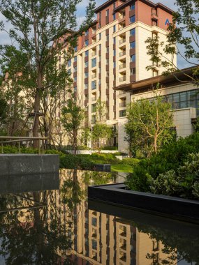 Etrafını çevreleyen mimari ve gökyüzünü yansıtan temiz çizgili bir su birikintisinin olduğu gösterişli, modern bir avlu. Görüntü meditasyon huzur, lüks yaşam, tasarım hassasiyeti ve akşam sükuneti taşır. Sığ ve yüksek kaliteli gerçek fotoğrafçılık