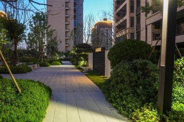 Gün batımında canlı bir bahçe parkına çıkan yapılandırılmış bir yürüyüş yolu. Görüntü mimari dengeyi, toplumsal uyumu, barışçıl doğayı ve akşam tasarımı güzelliğini aktarır. Sığ alan derinliğine sahip yüksek kaliteli gerçek fotoğrafçılık.