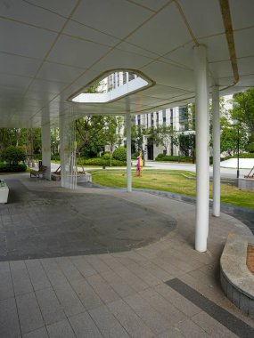 Çağdaş bir pavyonun, yemyeşil bahçe yapraklarıyla çevrili, eşsiz şekilli bir tavan aralığının olduğu bir perspektif manzarası. Görüntü tasarım yeniliği, barışçıl tefekkür, mimari güzellik ve sükunet içeriyor. Yüksek kaliteli gerçek fotoğrafçılık zekası.