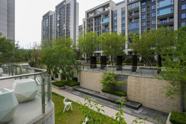 Taştan yollar, bir gölet ve yemyeşil peyzaj içeren modern bir bahçe parkının huzurlu yüksek açılı manzarası. Görüntü, toplumsal barışı, mekansal dengeyi, manzara tasarımını ve refahı taşır. Sığ ve yüksek kaliteli gerçek fotoğrafçılık