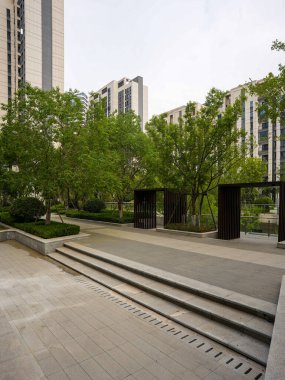 Çiçekli çalılar ve ağaçlarla çevrili taş basamakların dikey görüntüsü güzel manzaralı bir konut bahçesine çıkıyor. Görüntü tasarım düzeni, doğa bütünleşmesi, barış ve sofistike doğa yaşamını aktarıyor. Yüksek kaliteli gerçek fotoğrafçılık.