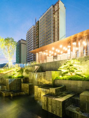 Akşamları arka planda gökdelenler olan modern bir su manzarası. Görüntü şehir manzarası, mimari ve lüks tasarım taşır. Yüksek kalite fotoğrafçılık.