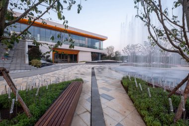 A modern building and fountain plaza captured during the twilight hour. The image conveys architectural mood, design, and outdoor serenity. High-quality photography.