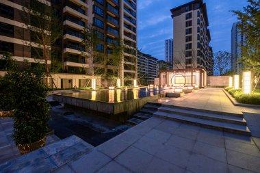 Tarif: Modern bir konut kompleksi içindeki bir çeşme bahçesinin huzurlu bir gece manzarası. Resim, huzurlu bir gece, tasarım ve mimari yapı içeriyor. Yüksek kalite fotoğrafçılık.