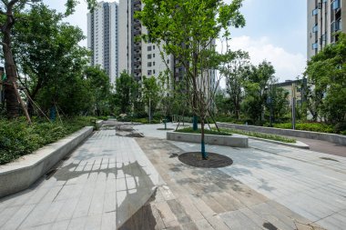 Eşkali: Akşamları çeşmeleri ve modern oturma yerleri olan peyzajlı bir yerleşim yeri. Görüntü, peyzaj tasarımı, dinginlik ve mimariyi taşır. Yüksek kalite fotoğrafçılık.