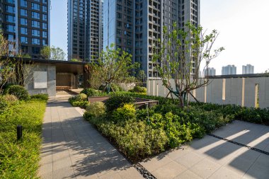 Tanımlama: Olgun ağaçlarla dolu yemyeşil bir bahçe boyunca uzanan taş bir patika. Görüntü, barış, doğa ve modern manzara tasarımını iletir. Yüksek kalite fotoğrafçılık.