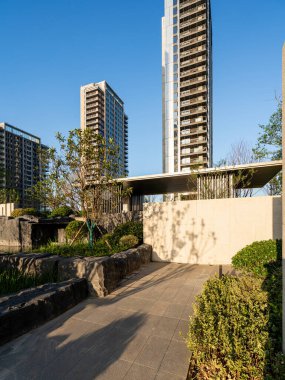 Tarif: Modern mimarisi olan peyzajlı bir konut parkında dolambaçlı taş bir patika. Resim, bahçe tasarımı, doğa ve huzurlu kentsel alan taşır. Yüksek kalite fotoğrafçılık.