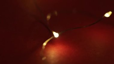 Kırmızı arka planda parıldayan Noel süsleri.