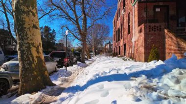 New York, ABD, 9 Ocak 2025 tuğla apartmanın yanında buzlu kaldırım. Buzlu kaldırım ve New York 'ta tuğla apartmanın yanına yığılmış kar..