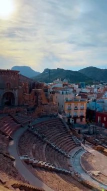 Alicante, İspanya, 9 Ağustos 2025: Antik Roma Tiyatrosu şehir manzaralı ve dağlı. Cartagena İspanya 'daki Roma Tiyatrosu' nun manzarası yükseldi