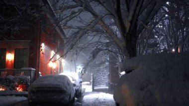 New York, ABD, 20 Şubat 2026, yoğun gece karı ile kaplı ev ve garaj yolu. Tuğladan bir evin yan görüntüsü ve New York 'ta büyük bir kar birikintisinin altında kalmış park edilmiş bir araba.