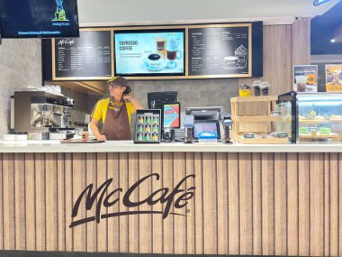 Jakarta, Endonezya - 15 Ocak 2026 - Jakarta 'da bir McDonald' s ve McCaf restoranının dış tarafında müşteriler akşam lambaları altında yemek yiyor..