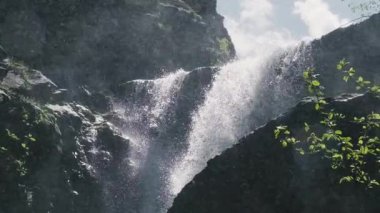 Bir Gürcü şelalesinin büyüleyici yavaş çekim gücü yazın ortasında havada asılı duran su damlacıklarıyla. Bu sakin doğa sahnesi meditasyon ve farkındalığın özünü somutlaştırıyor, çağlayan su ve uçan damlacıklar