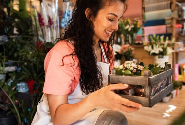 Çiçekçide çalışan kadın çiçekçi. Çiçek düzenliyor..