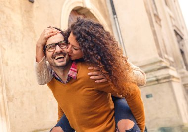 Mutlu çift, güneşli bir sonbahar gününde şehirde yürürken eğleniyor..