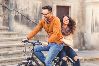 Mutlu çift şehirde güneşli bir sonbahar gününde bisiklet sürerken eğleniyor..