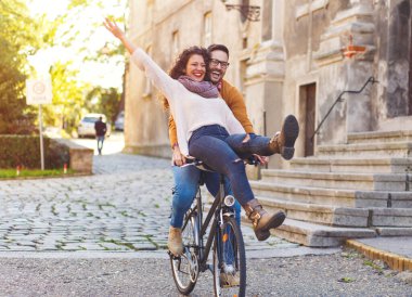 Mutlu çift şehirde güneşli bir sonbahar gününde bisiklet sürerken eğleniyor..