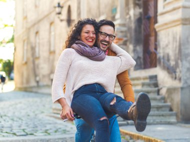 Mutlu çift şehirde güneşli bir sonbahar gününde bisiklet sürerken eğleniyor..