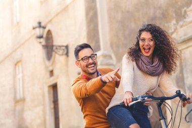 Mutlu çift şehirde güneşli bir sonbahar gününde bisiklet sürerken eğleniyor..