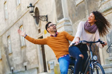 Mutlu çift şehirde güneşli bir sonbahar gününde bisiklet sürerken eğleniyor..