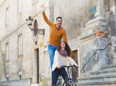 Mutlu çift şehirde güneşli bir sonbahar gününde bisiklet sürerken eğleniyor..