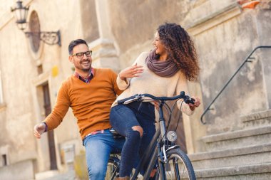 Mutlu çift şehirde güneşli bir sonbahar gününde bisiklet sürerken eğleniyor..