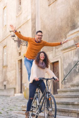 Mutlu çift şehirde güneşli bir sonbahar gününde bisiklet sürerken eğleniyor..